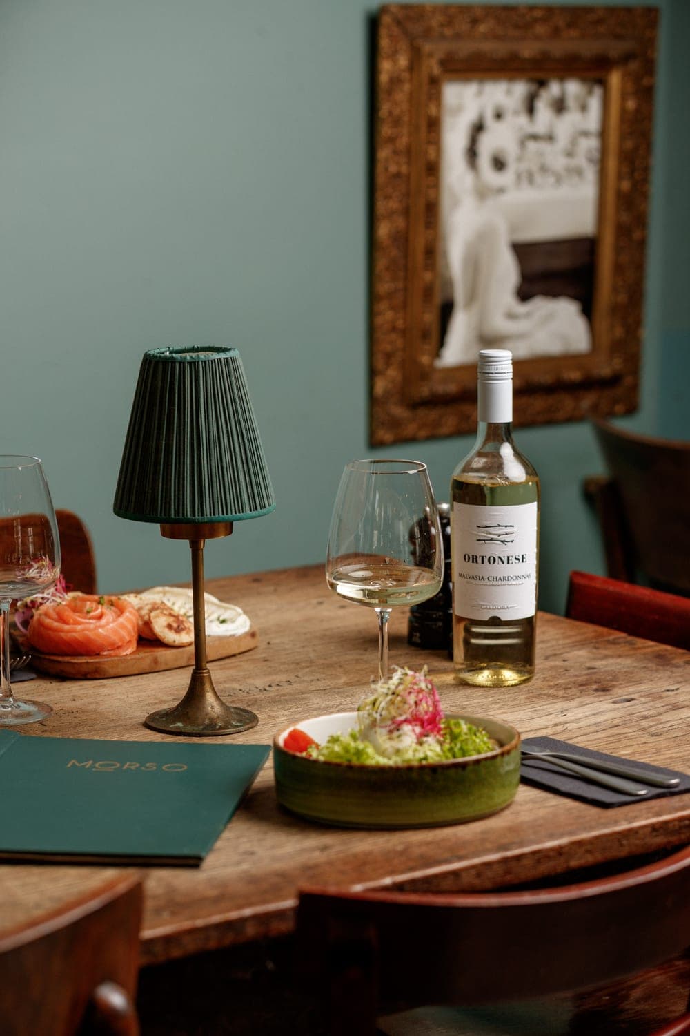 Een gedekte tafel met een glas wijn in het interieur van restaurant Morso